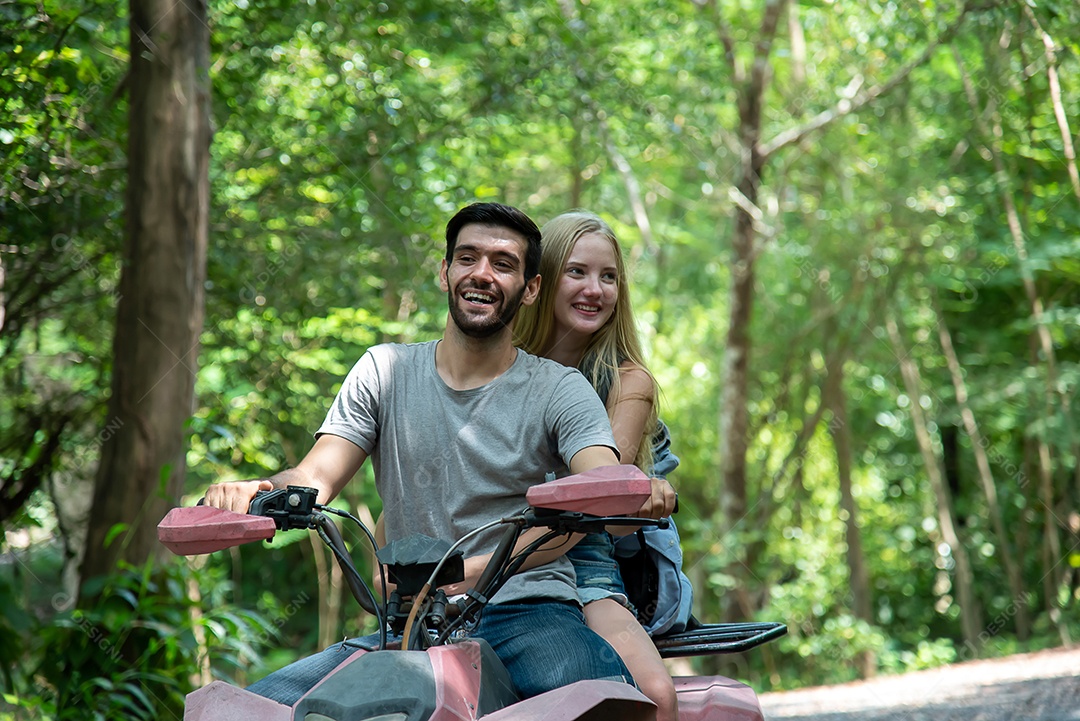 Casal anda de quadriciclo e atravessa a floresta com alegria e entusiasmo