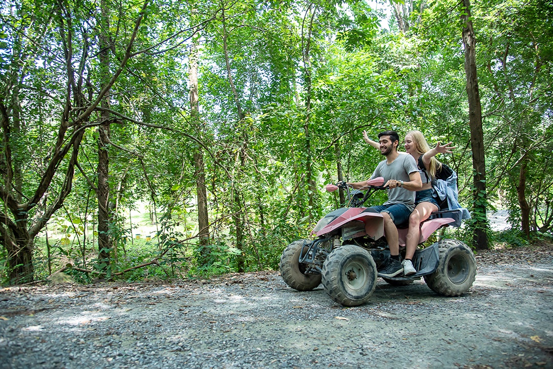 Jovem casal anda de quadriciclo, atravessa a floresta com alegria e emoção
