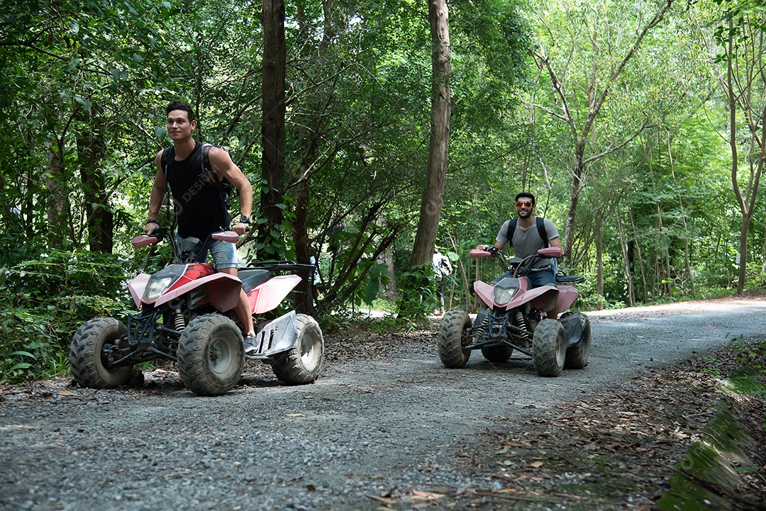 Amigos andam de quadriciclo e atravessam a floresta com alegria e entusiasmo