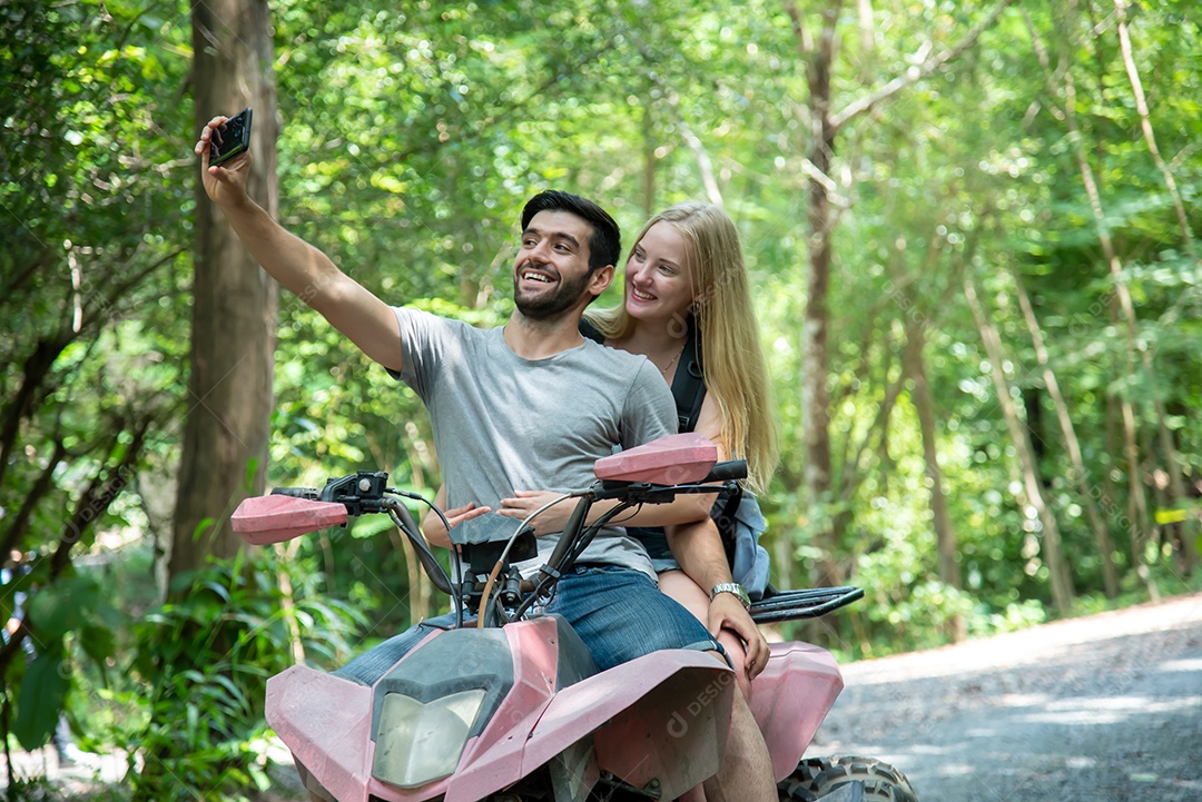 Homem tirando selfie com a namorada em pé no quadriciclo