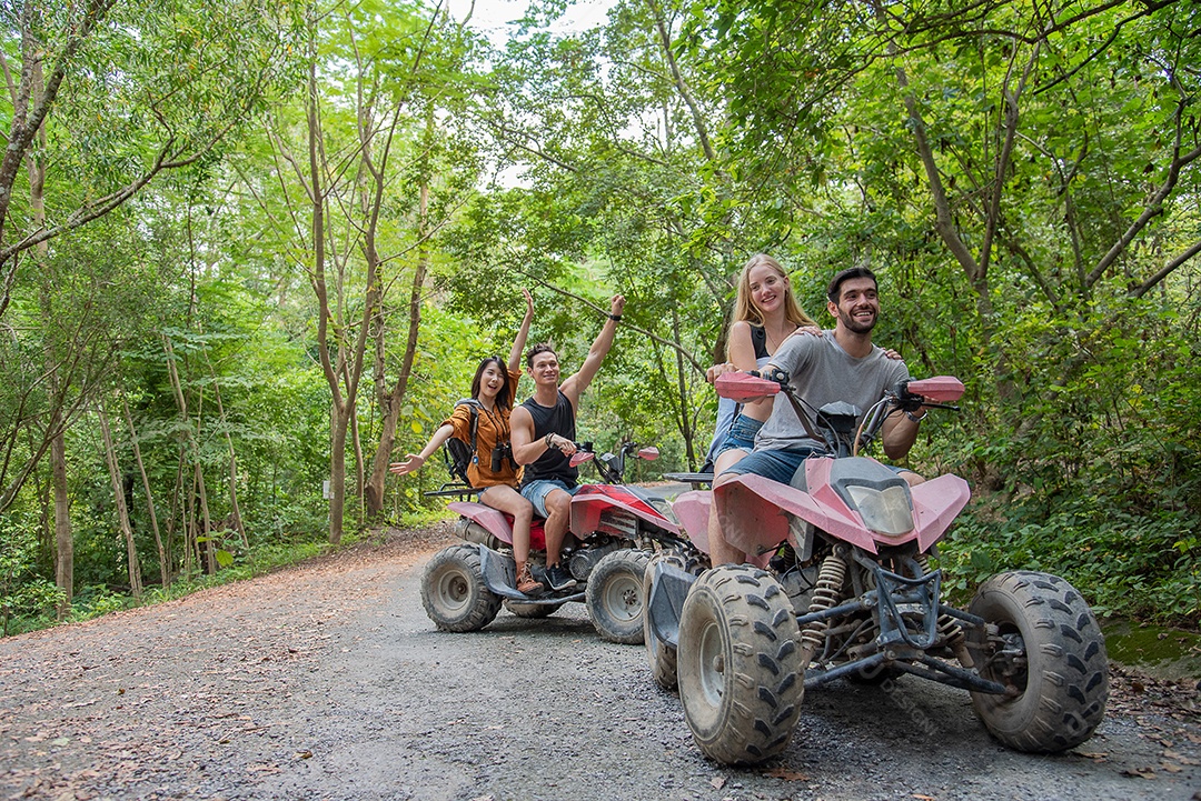 Jovem casal ou amigo feliz enquanto andava de quadriciclo na floresta