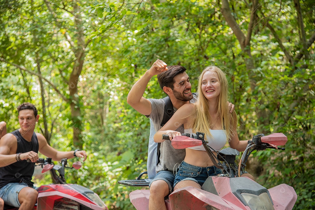 Jovem casal ou amigo feliz enquanto andava de quadriciclo na floresta