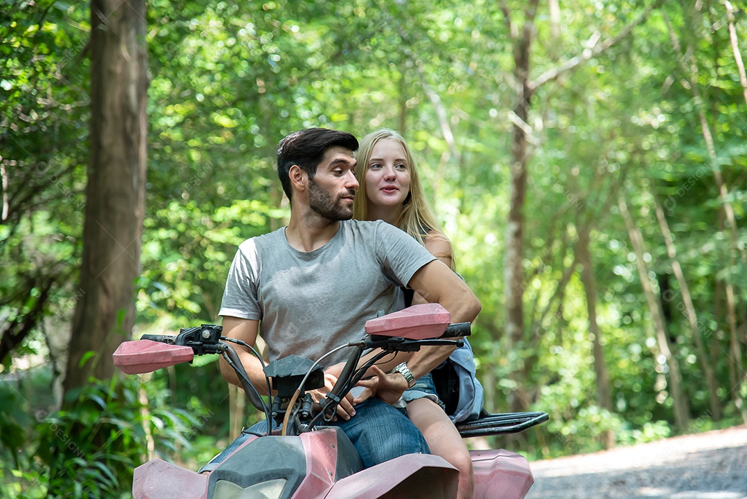 Jovem casal anda de quadriciclo, atravessa a floresta com alegria e emoção
