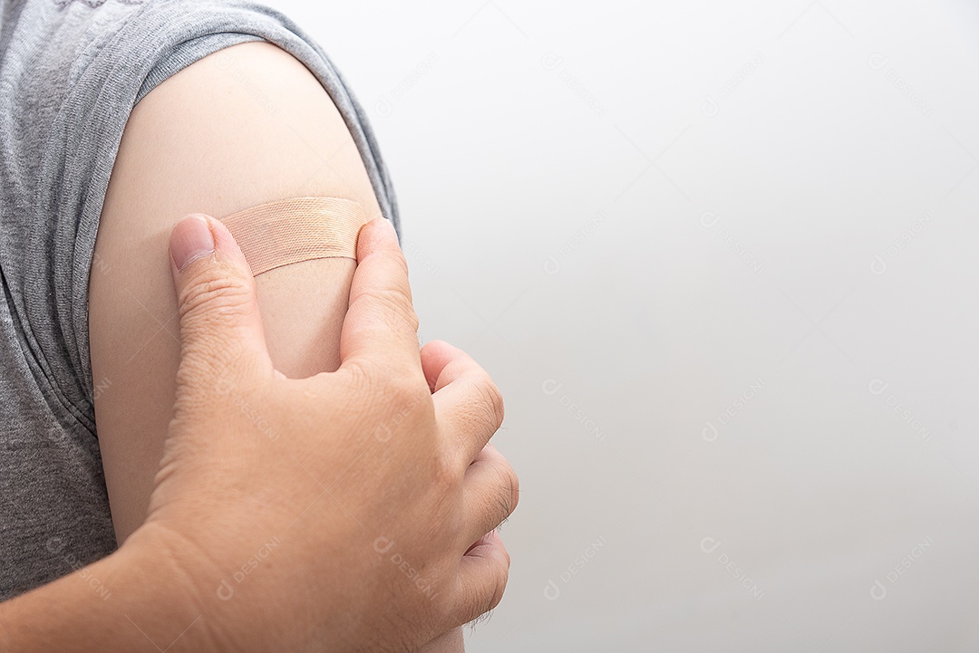 Homem asiático toca emplastros medicinais depois de ser vacinado