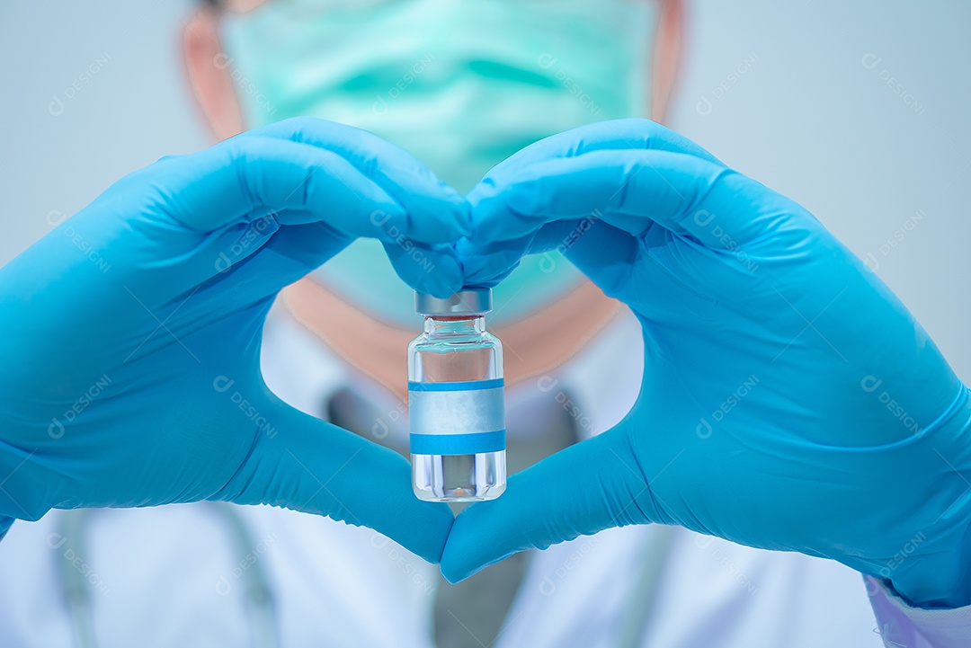 O médico usando uma máscara fez um sinal de mão em forma de coração segurando vacina