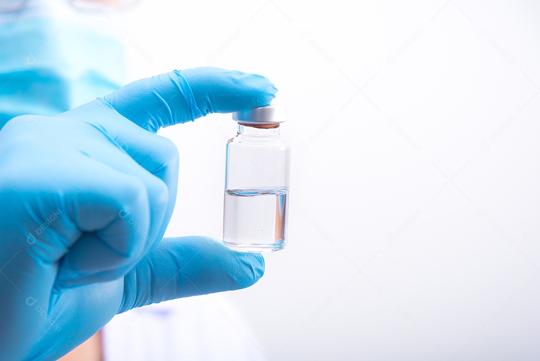 O médico usando luvas e máscara azuis está segurando a vacina contra o vírus