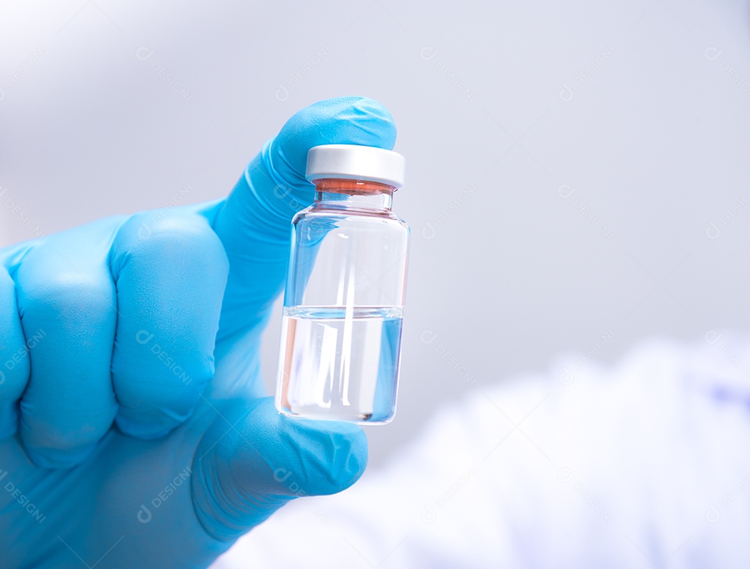 Médico usando luvas azuis está segurando a vacina contra o vírus Corona