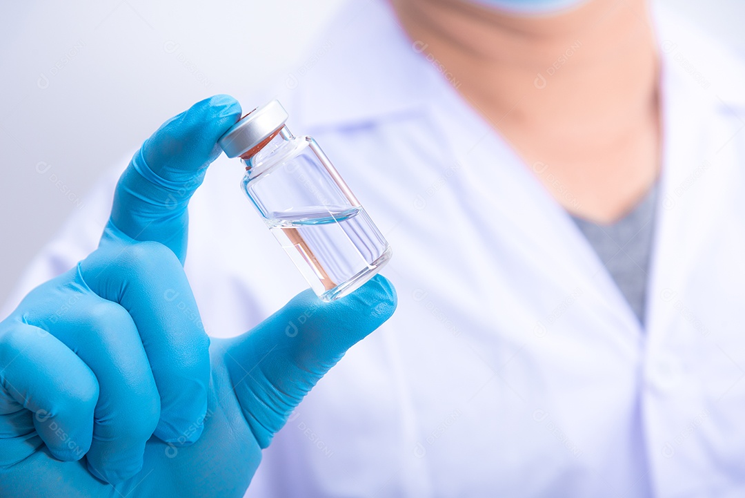 Médico usando luvas azuis está segurando a vacina contra o vírus Corona