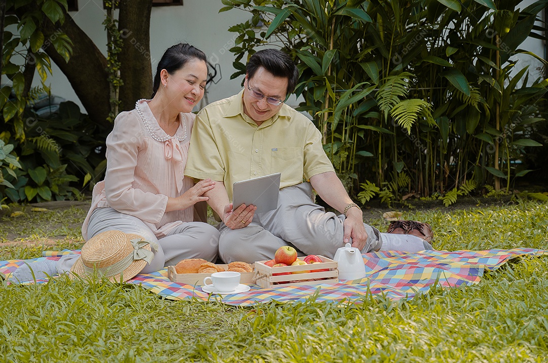 Casal asiático relaxando em casa e comendo.