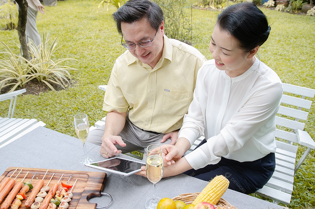 Casal asiático relaxando em casa e comendo.