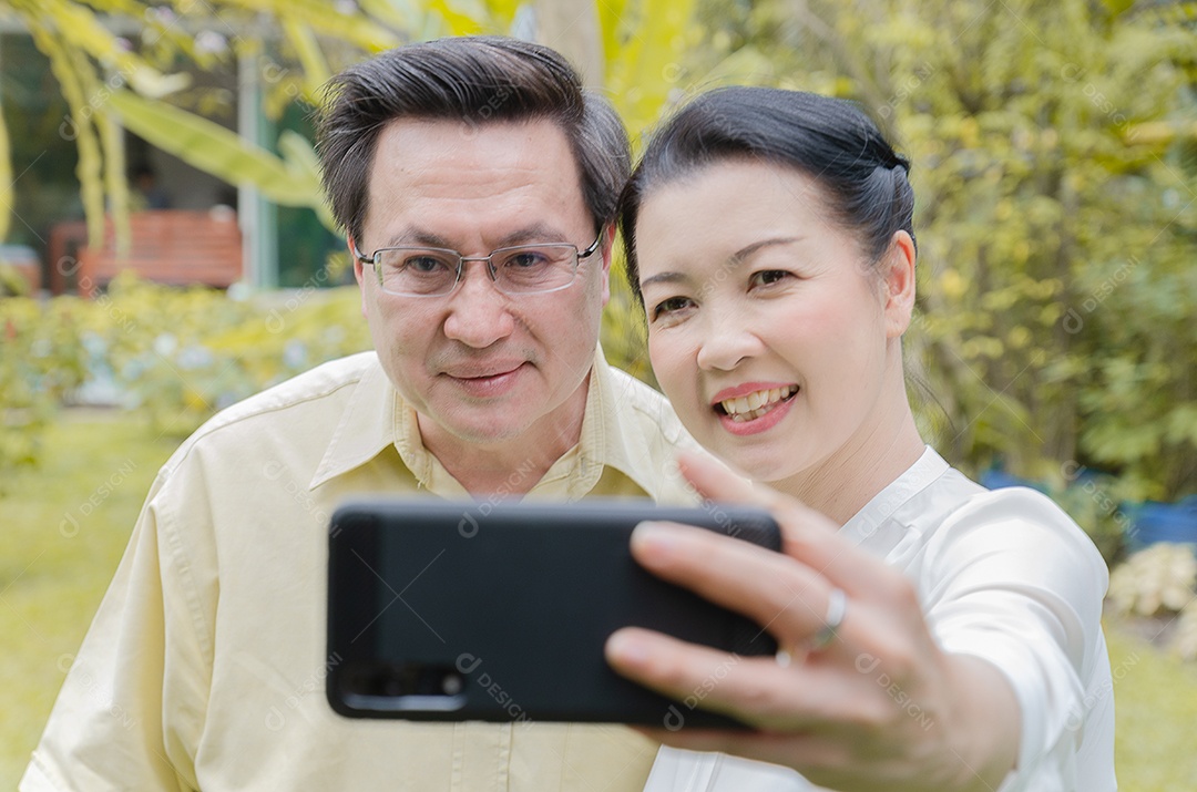 Casal asiático relaxando em casa e comendo. e tirar foto