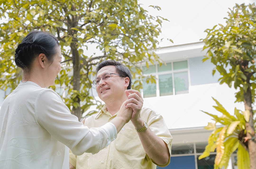 Casal sênior asiático sorrindo, feliz, em casa vivendo uma boa vida