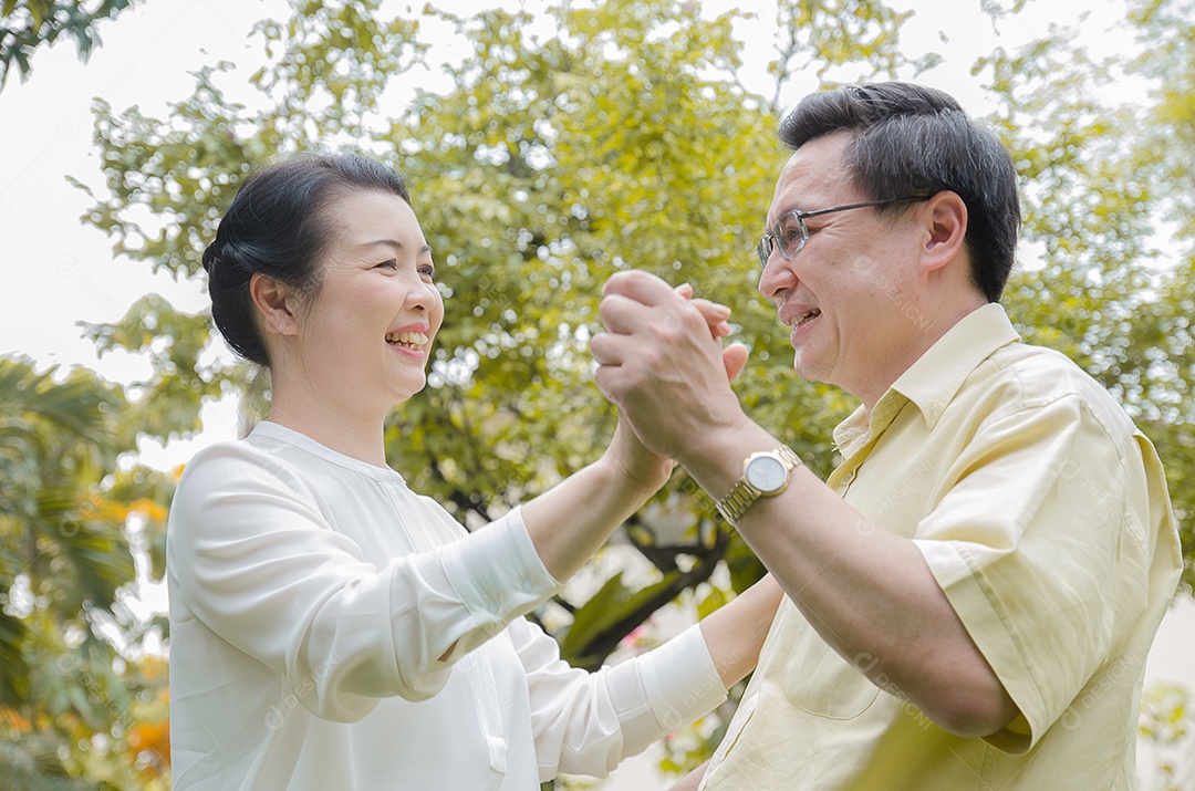 Casal sênior asiático sorrindo, feliz, em casa vivendo uma boa vida