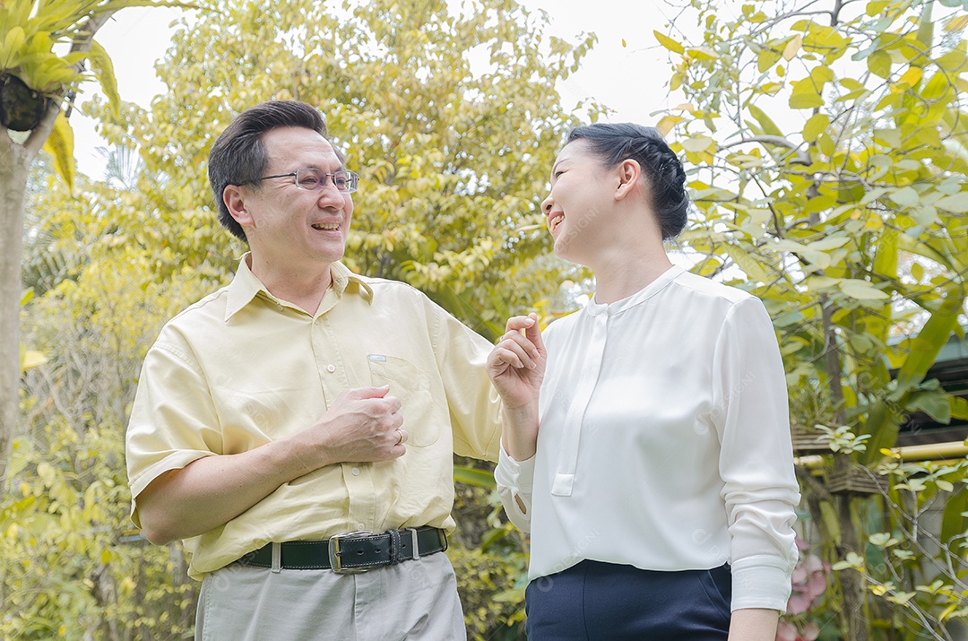Casal sênior asiático sorrindo, feliz, em casa vivendo uma boa vida