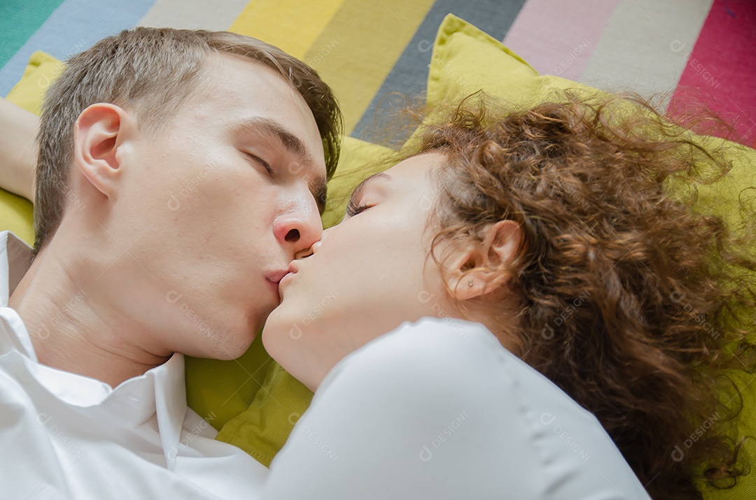Lindo casal jovem se beijando na cama