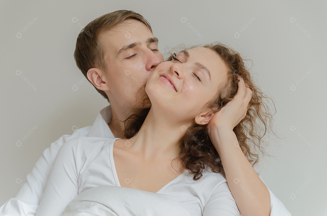 Casal jovem bonito beijando na cama