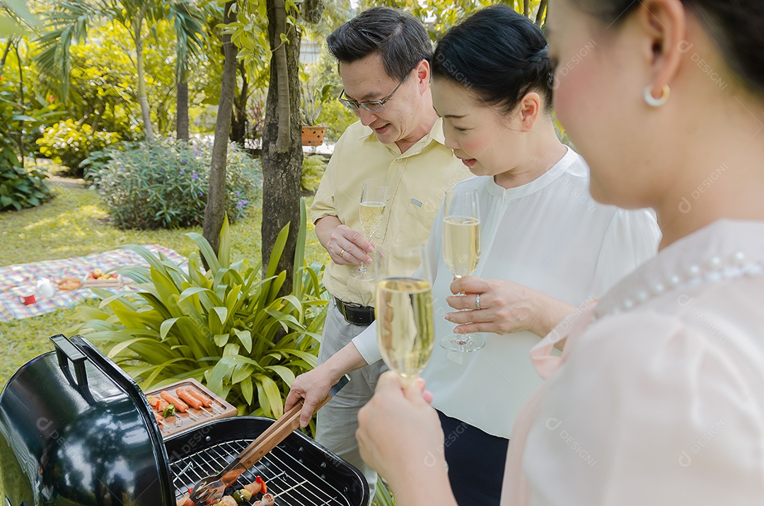 Grupo de idosos comemorando com vinho branco e churrasco