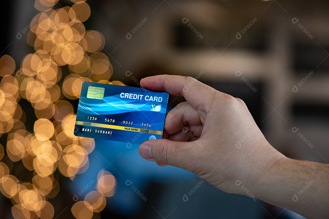 Mão segure o fundo azul do bokeh dos cartões de crédito