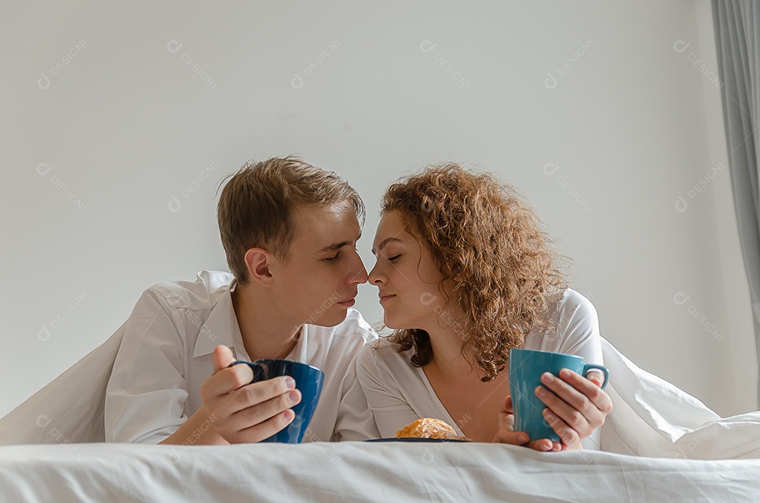 Belo casal jovem tomando café da manhã e bebendo café