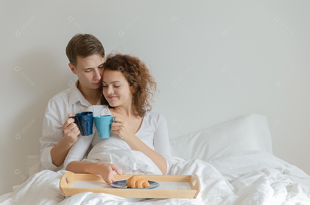 Belo casal jovem tomando café da manhã e bebendo café