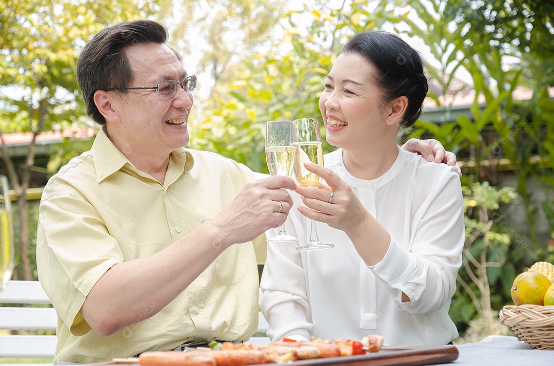 Idosos comemorando com vinho branco e churrasco