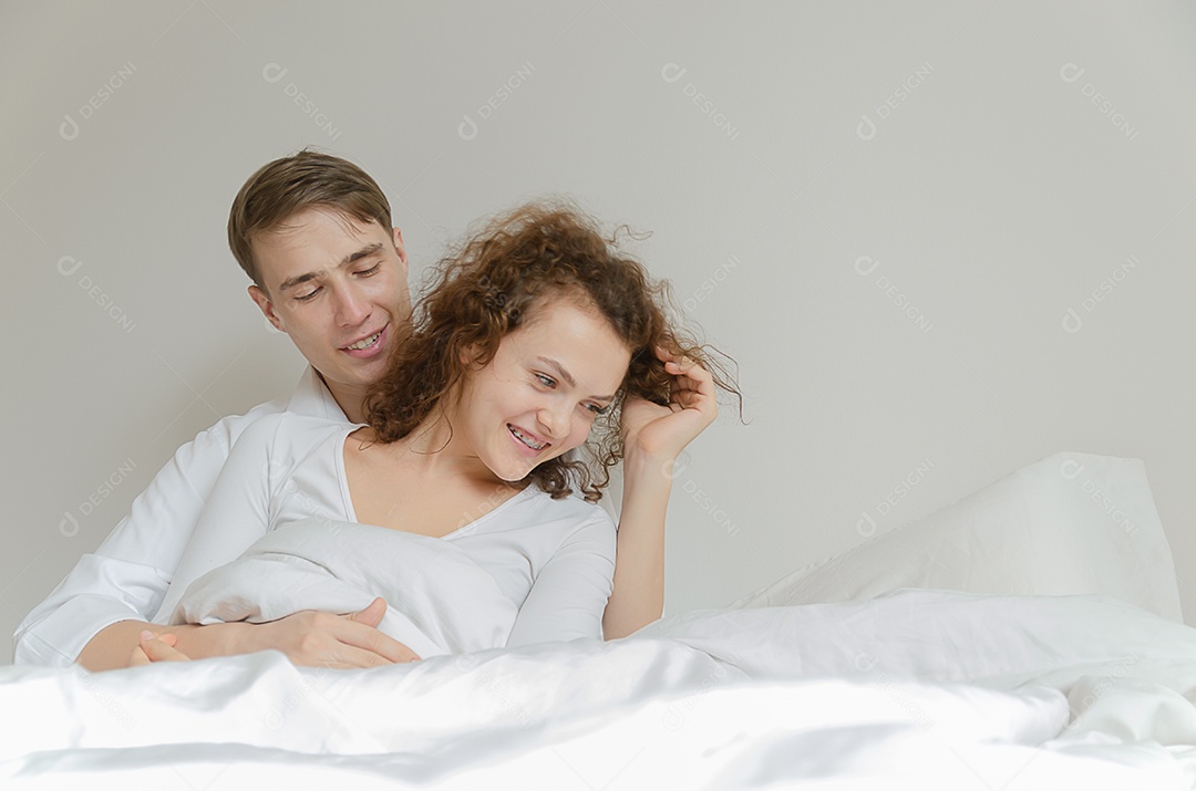 Jovem casal na cama provocando uns aos outros
