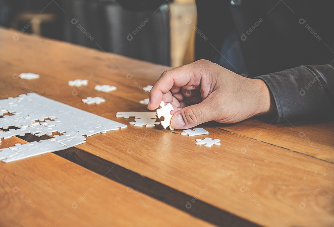Empresário segurando branco quebra-cabeça e conectar juntos