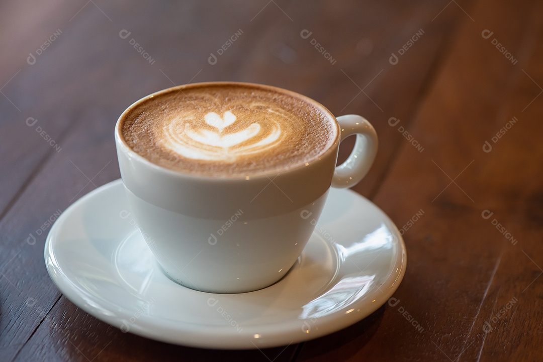 Xícara de café com leite ou cappuccino na mesa de madeira
