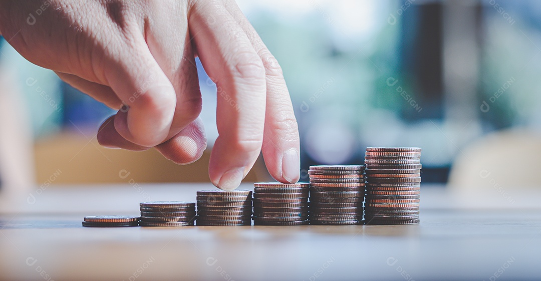 Dedos subindo em pilhas de moedas