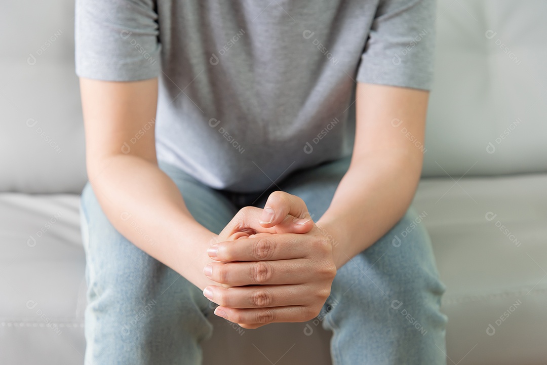 Mulher sentou no sofá e segurou sua mão para rezar