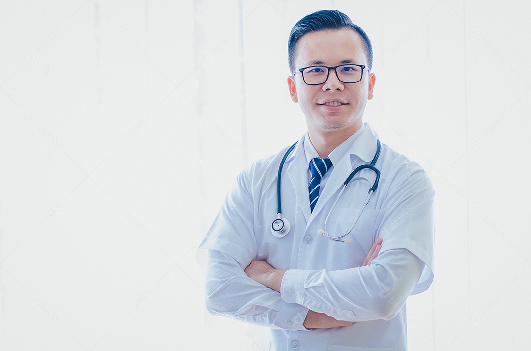 O médico asiático está usando um estetoscópio com os braços cruzados