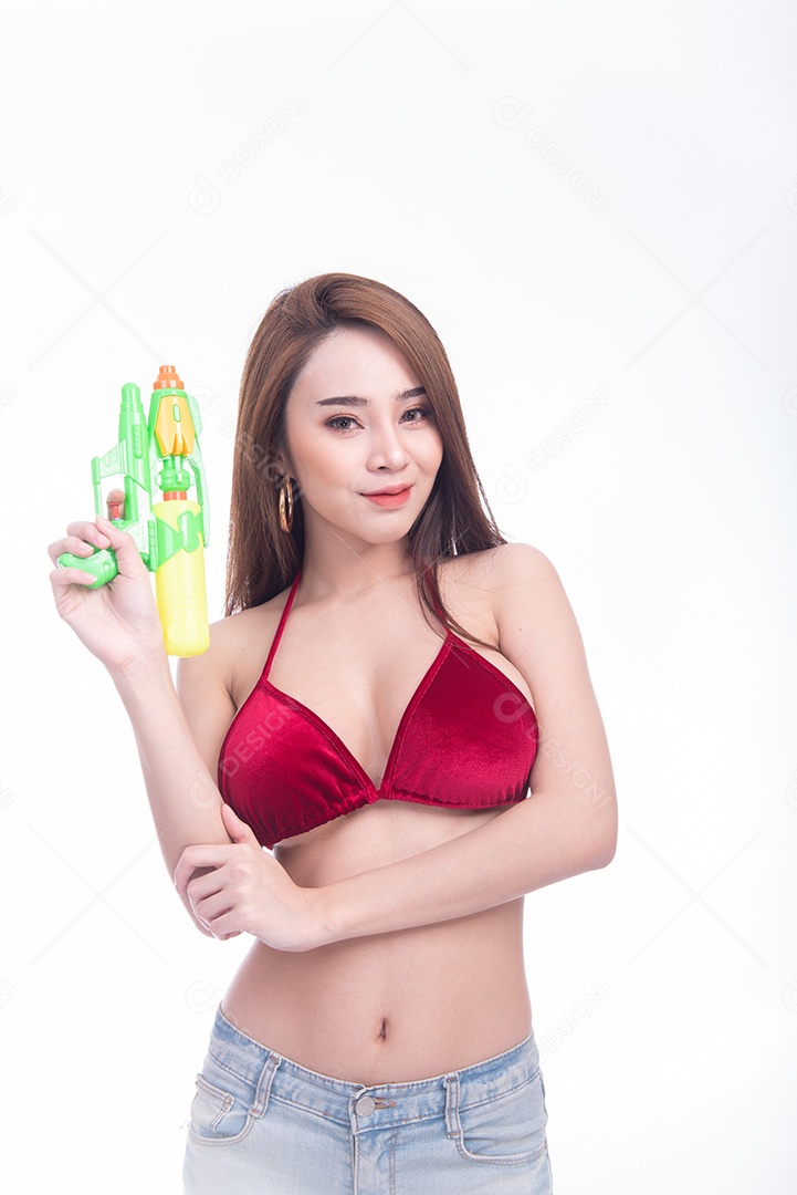 Bela jovem mulher asiática segurando a arma de água e sorriso