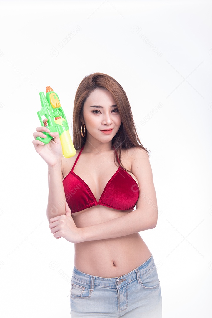 Bela jovem mulher asiática segurando a arma de água e sorriso