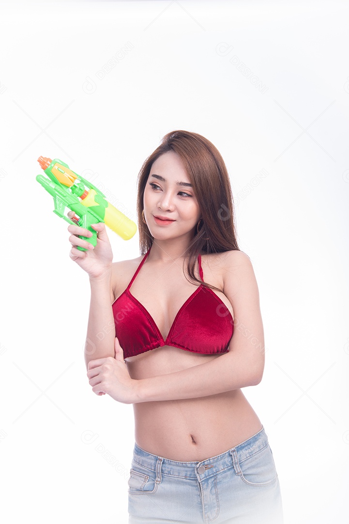 Bela jovem mulher asiática segurando a arma de água e sorriso