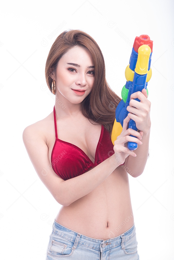 Bela jovem mulher asiática segurando a arma de água e sorriso