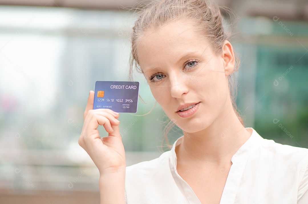 Mulher jovem e bonita sorrindo enquanto usa cartão de crédito para online