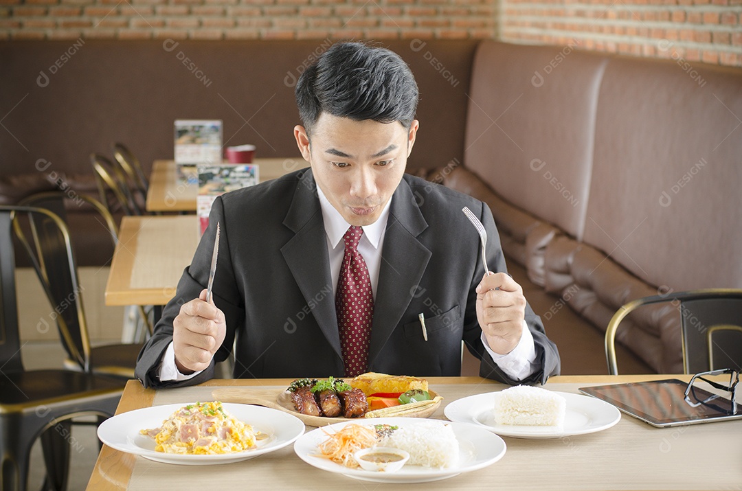 homem de negócios feliz comendo alimentos no restaurante e tablet na mesa