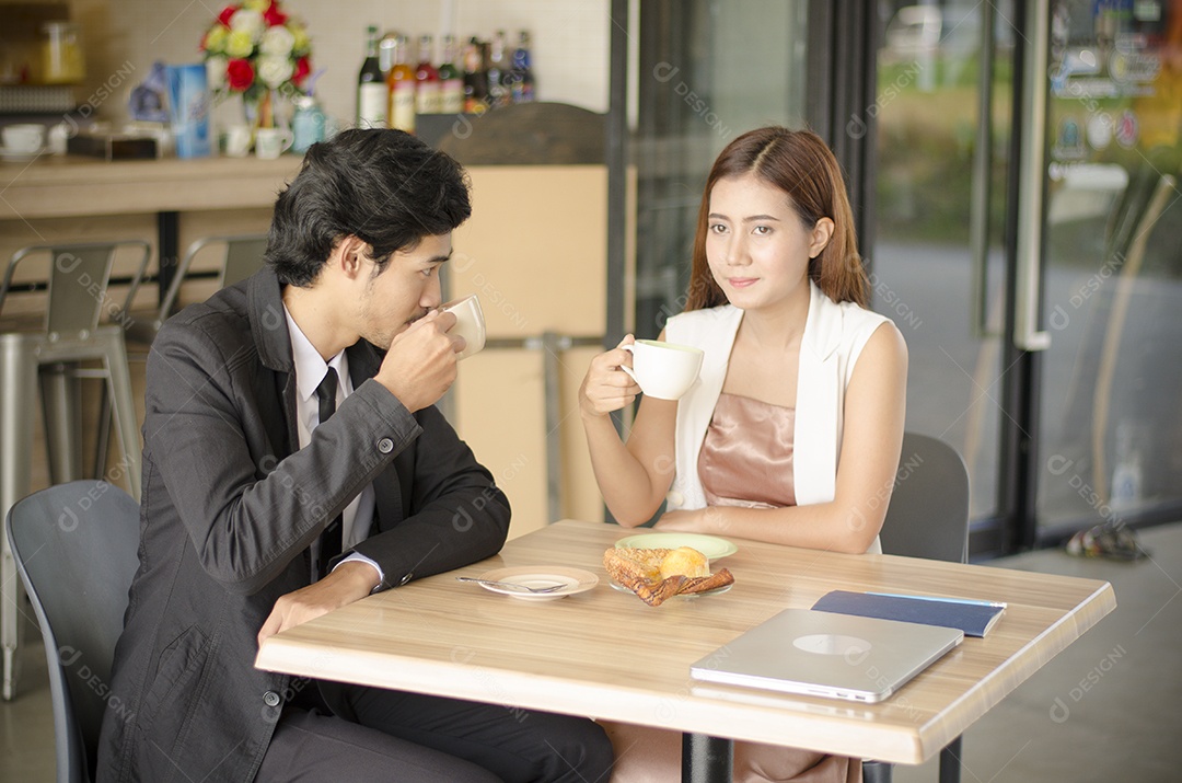 Casal tomando café e tendo padaria na cafeteria