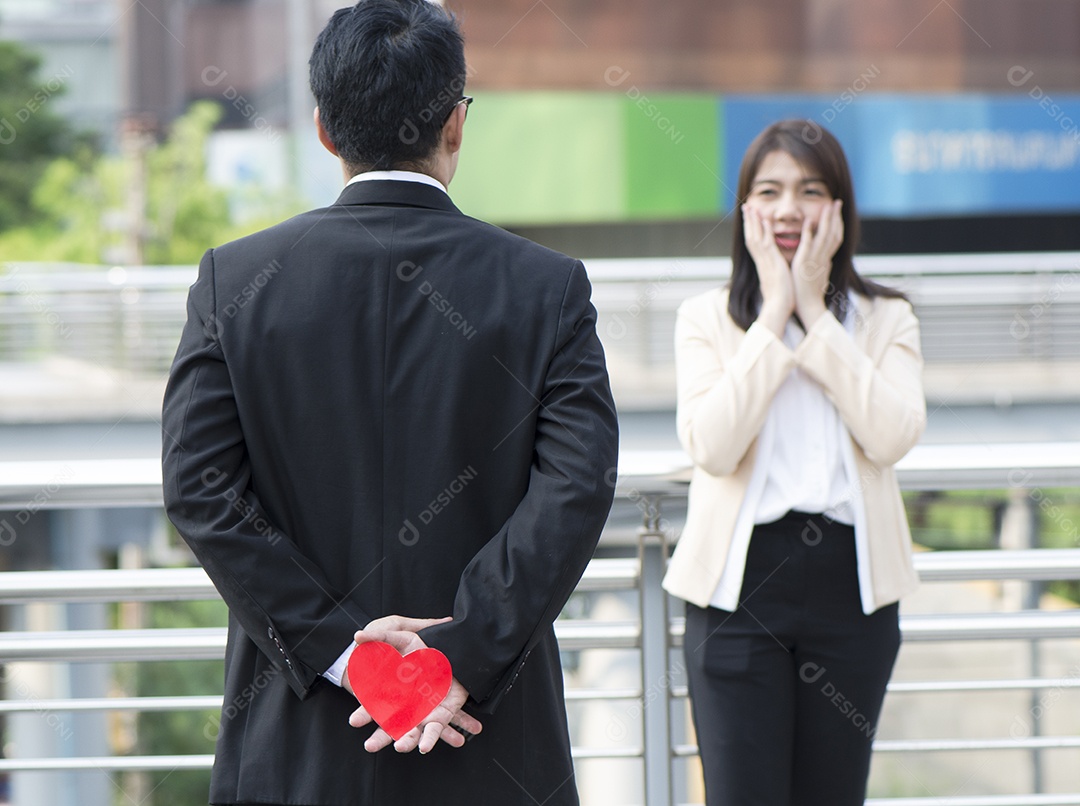 homem de negócios está segurando o coração vermelho nas costas na cidade
