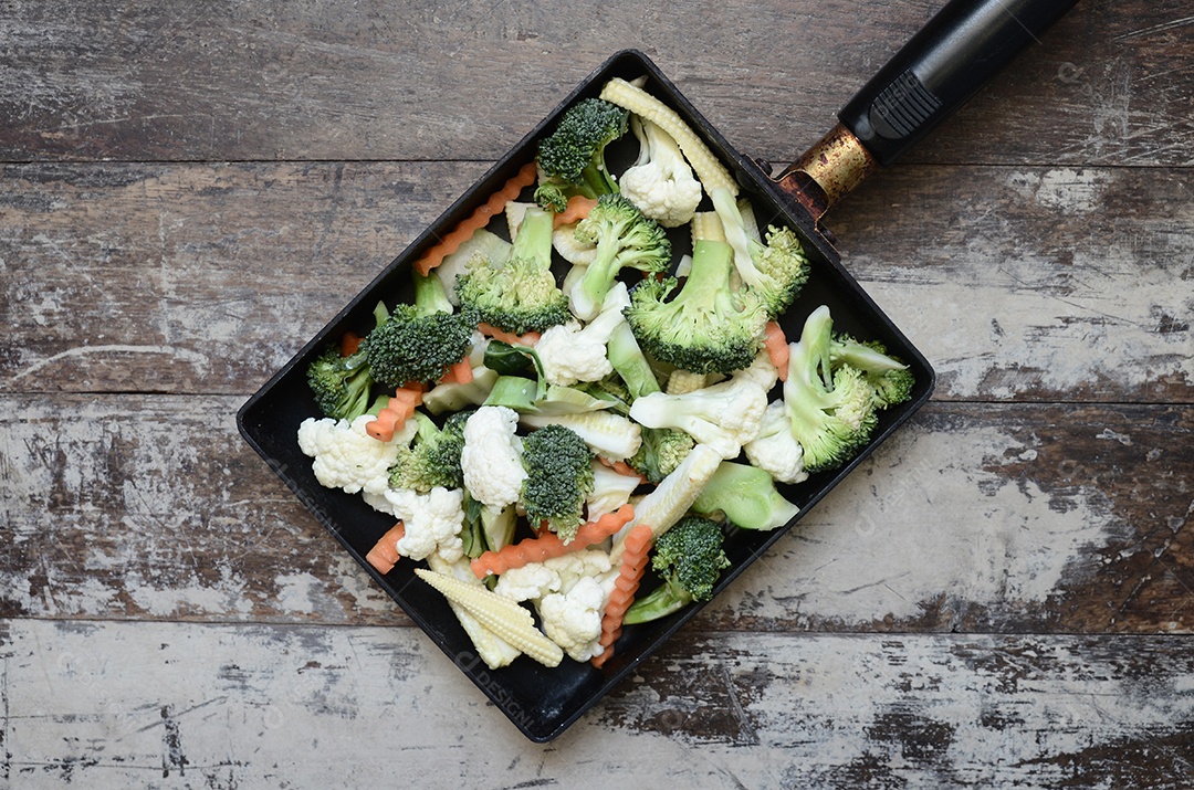 Legumes em uma panela na madeira