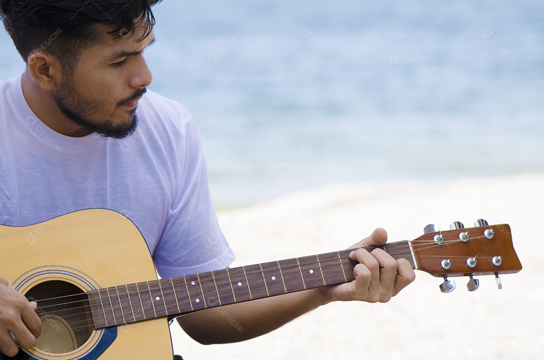 Jovem tocando violão na praia