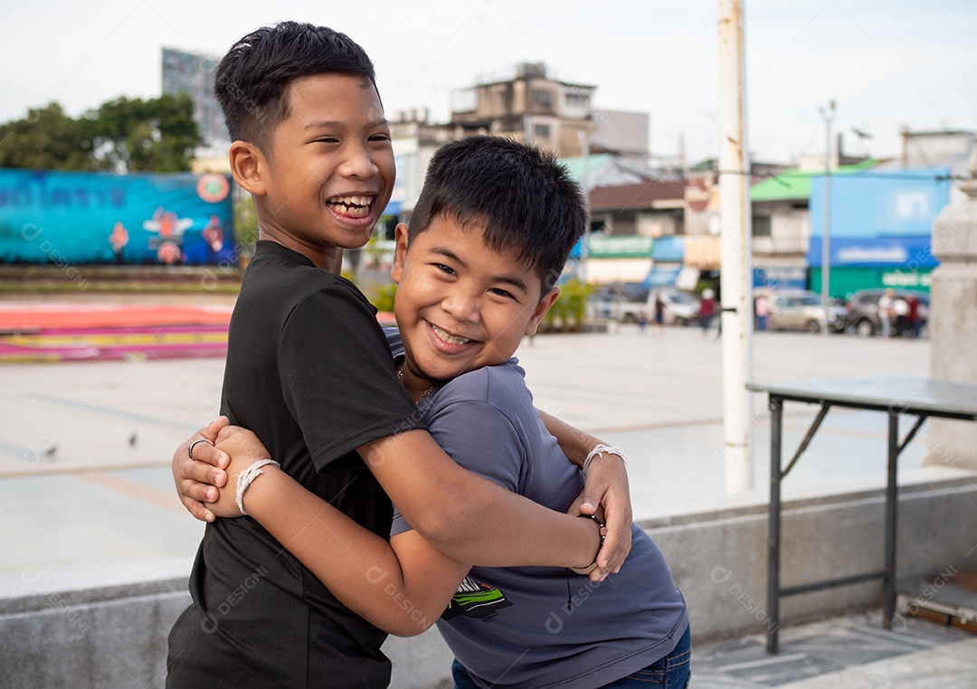 Irmãos se abraçando e sorrindo alegremente.