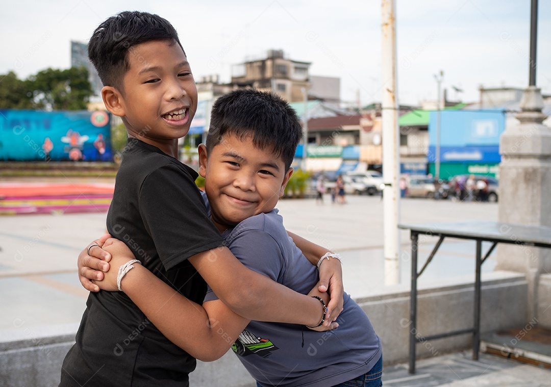 Irmãos se abraçando e sorrindo alegremente.