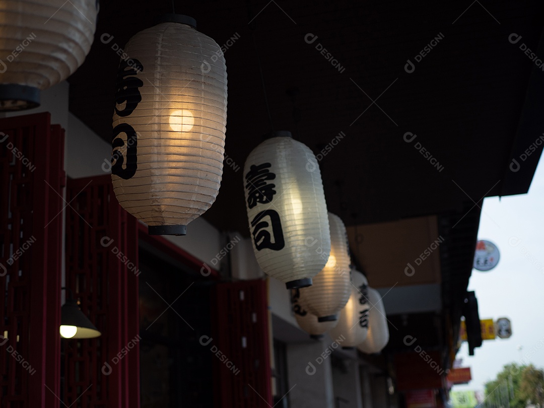 Lanterna japonesa pendurada na frente do restaurante japonês, o texto japonês na lanterna é comida japonesa Sushi.