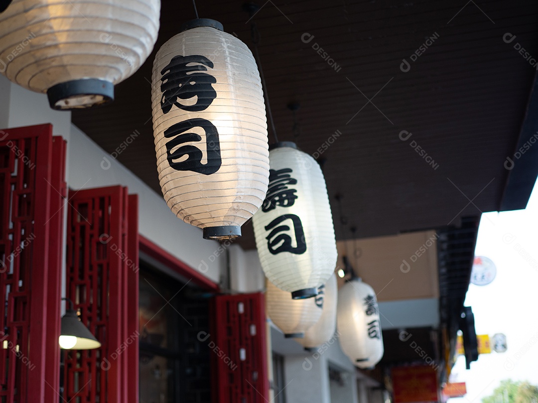 Lanterna japonesa pendurada na frente do restaurante japonês, o texto japonês na lanterna é comida japonesa Sushi.