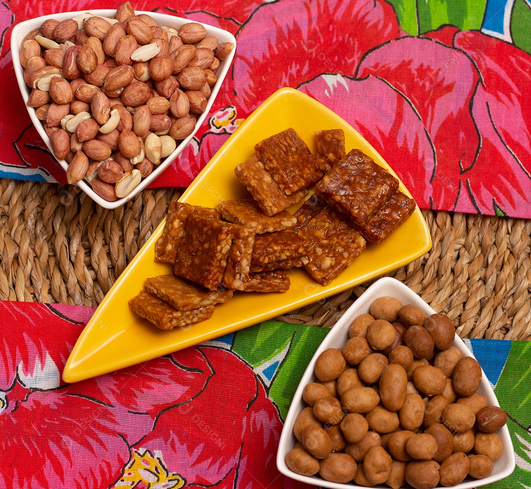 Três tigelas cheias de doces de amendoim na mesa de palha