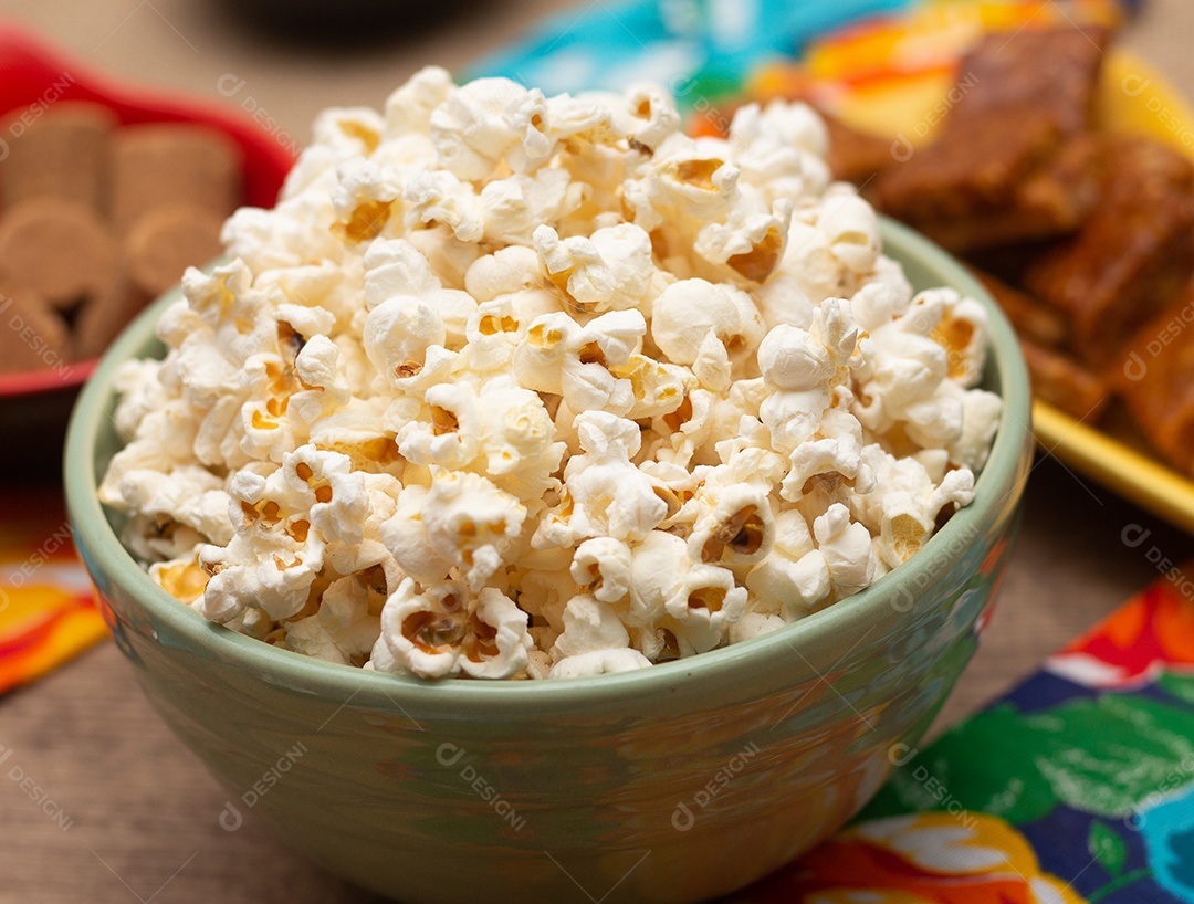 tigela grande com pipoca e amendoim em cima da mesa