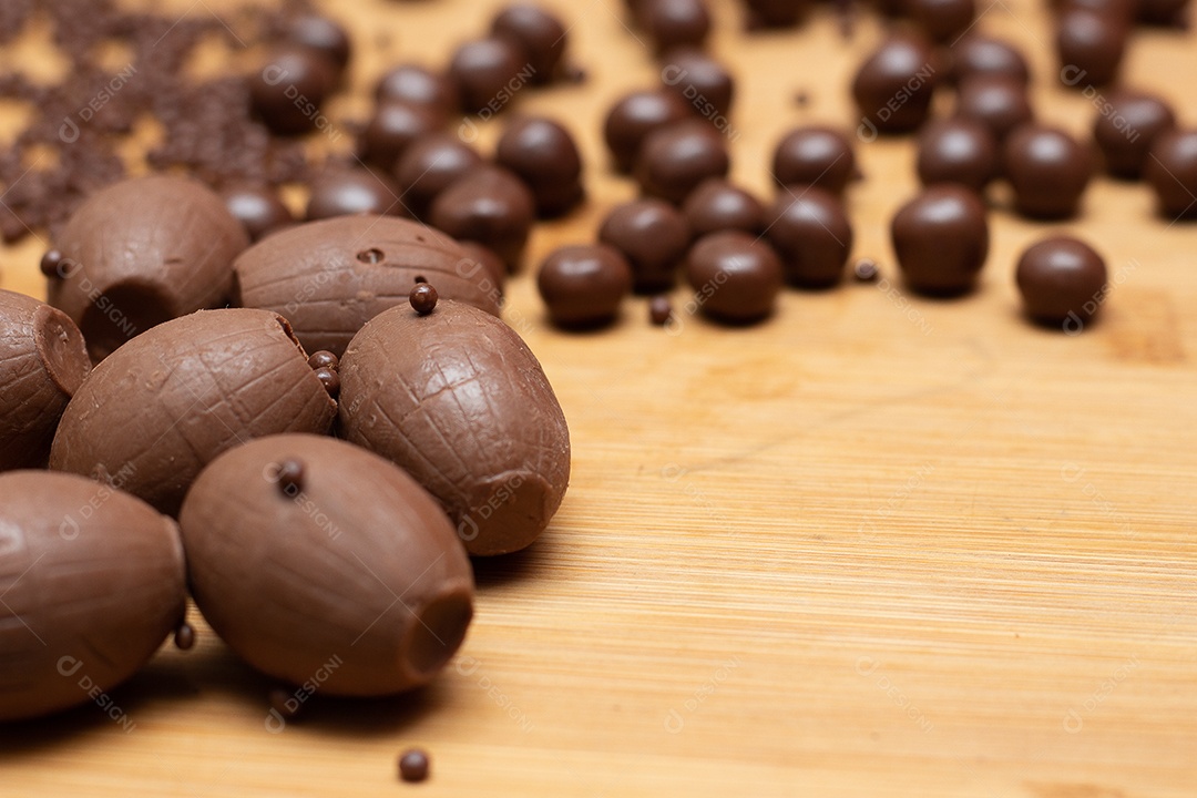 Diferentes tipos de bolas de chocolate em uma tigela cinza com uma colher cheia de chocolate