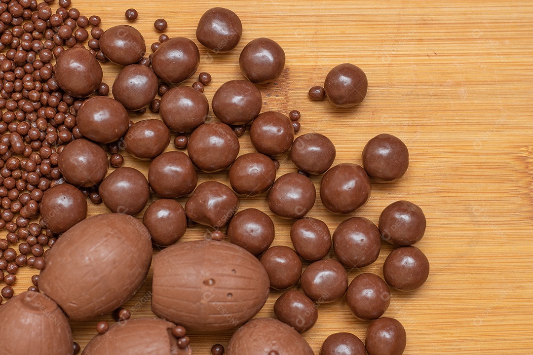 Diferentes tipos de bolas de chocolate em uma tigela cinza com uma colher cheia de chocolate