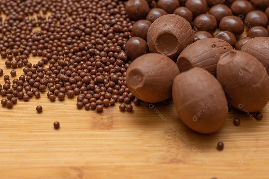 Different types of chocolate balls in a gray bowl with a spoon full of chocolate